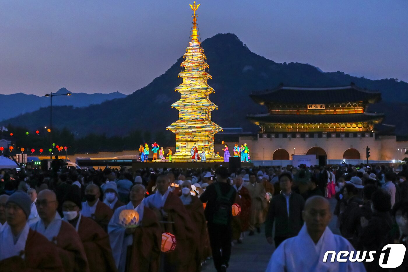 본문 이미지 - 26일 오후 서울 종로구 광화문광장에서 열린 '2023 부처님오신날 봉축점등식'에서 참석자들이 철물 구조와 한지 공예로 만든 높이 20m의 수마노탑 주변 탑돌이를 하고 있다. 2023.4.26/뉴스1 ⓒ News1 민경석 기자