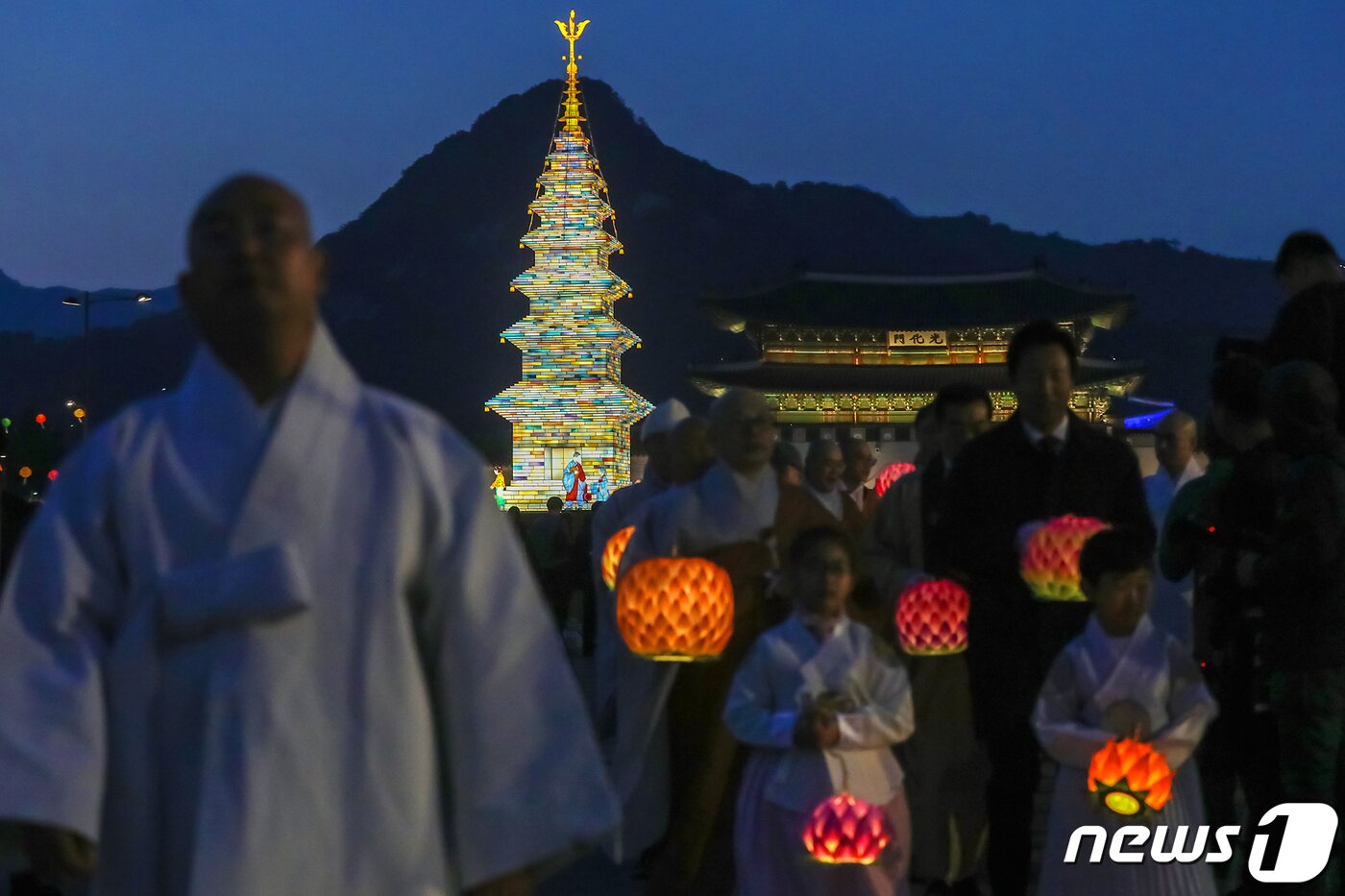 본문 이미지 - 26일 오후 서울 종로구 광화문광장에서 열린 '2023 부처님오신날 봉축점등식'에서 참석자들이 철물 구조와 한지 공예로 만든 20m 높이의 수마노탑 주변 탑돌이를 하고 있다. 2023.4.26/뉴스1 ⓒ News1 민경석 기자
