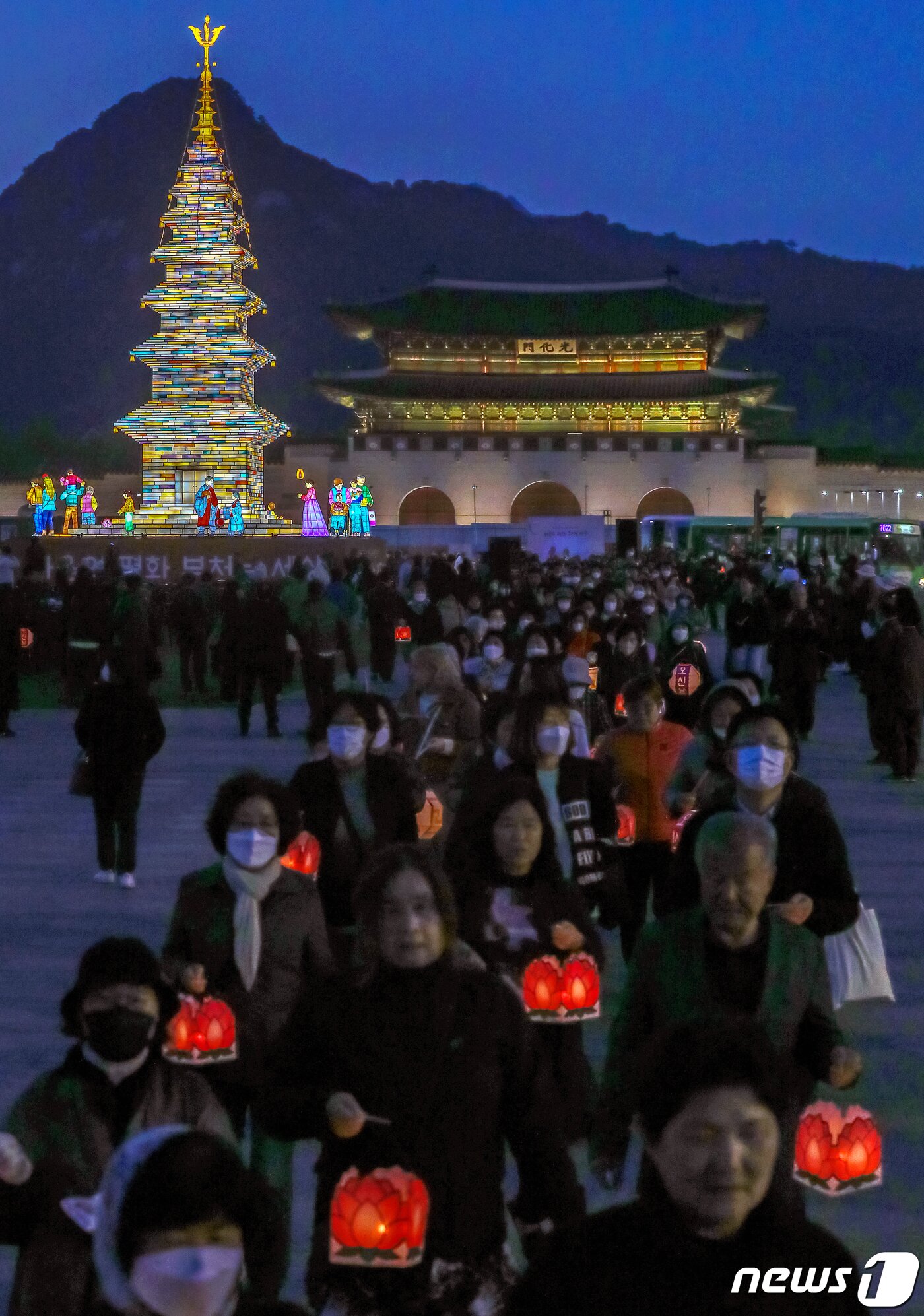 본문 이미지 - 26일 오후 서울 종로구 광화문광장에서 열린 '2023 부처님오신날 봉축점등식'에서 참석자들이 철물 구조와 한지 공예로 만든 20m 높이의 수마노탑 주변 탑돌이를 하고 있다. 2023.4.26/뉴스1 ⓒ News1 민경석 기자
