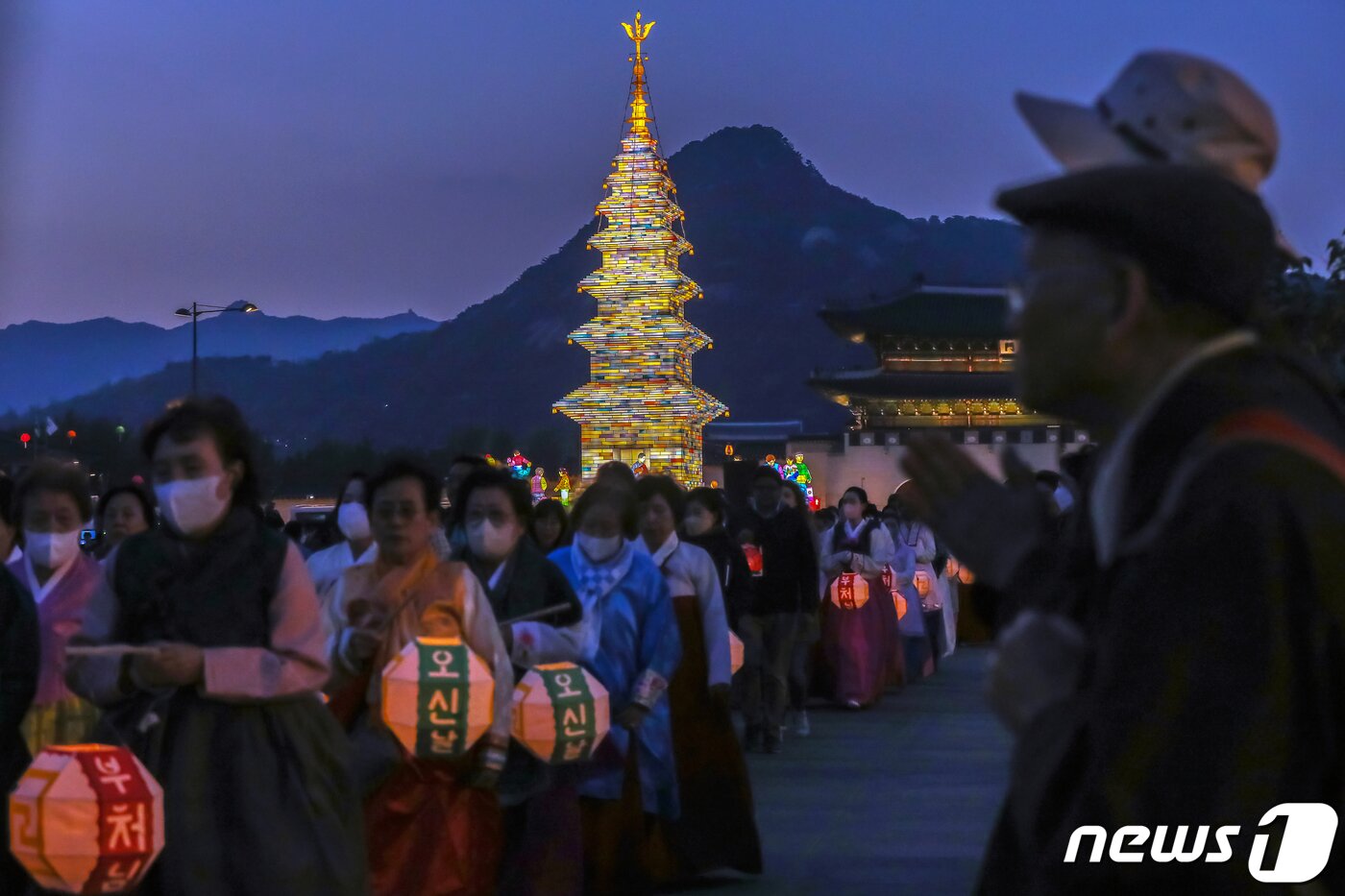 본문 이미지 - 26일 오후 서울 종로구 광화문광장에서 열린 '2023 부처님오신날 봉축점등식'에서 참석자들이 철물 구조와 한지 공예로 만든 20m 높이의 수마노탑 주변 탑돌이를 하고 있다. 2023.4.26/뉴스1 ⓒ News1 민경석 기자