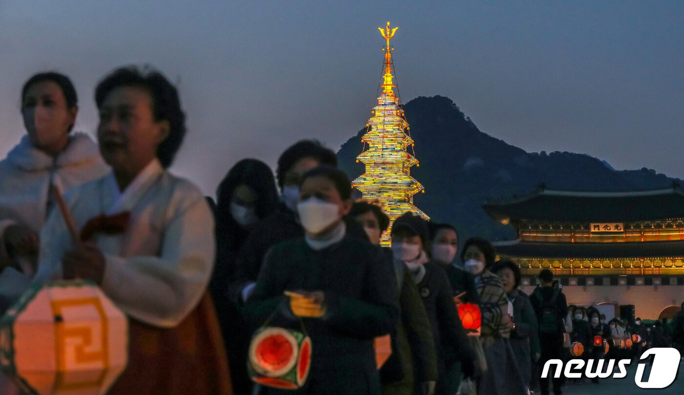 본문 이미지 - 26일 오후 서울 종로구 광화문광장에서 열린 '2023 부처님오신날 봉축점등식'에서 참석자들이 철물 구조와 한지 공예로 만든 20m 높이의 수마노탑 주변 탑돌이를 하고 있다. 2023.4.26/뉴스1 ⓒ News1 민경석 기자