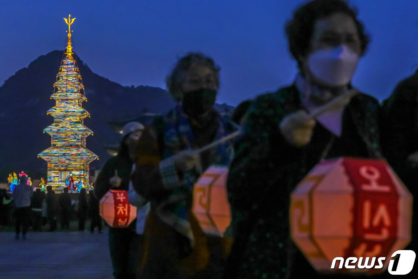 본문 이미지 - 26일 오후 서울 종로구 광화문광장에서 열린 '2023 부처님오신날 봉축점등식'에서 참석자들이 철물 구조와 한지 공예로 만든 20m 높이의 수마노탑 주변 탑돌이를 하고 있다. 2023.4.26/뉴스1 ⓒ News1 민경석 기자