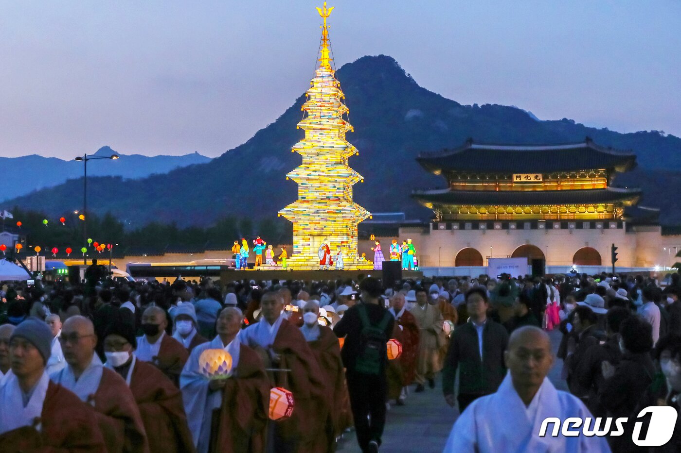 본문 이미지 - 26일 오후 서울 종로구 광화문광장에서 열린 '2023 부처님오신날 봉축점등식'에서 참석자들이 철물 구조와 한지 공예로 만든 20m 높이의 수마노탑 주변 탑돌이를 하고 있다. 2023.4.26/뉴스1 ⓒ News1 민경석 기자
