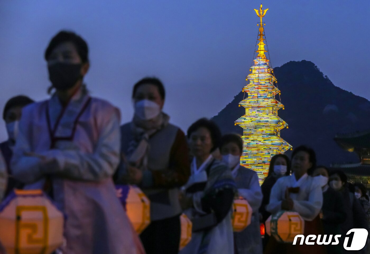 본문 이미지 - 26일 오후 서울 종로구 광화문광장에서 열린 '2023 부처님오신날 봉축점등식'에서 참석자들이 철물 구조와 한지 공예로 만든 20m 높이의 수마노탑 주변 탑돌이를 하고 있다. 2023.4.26/뉴스1 ⓒ News1 민경석 기자