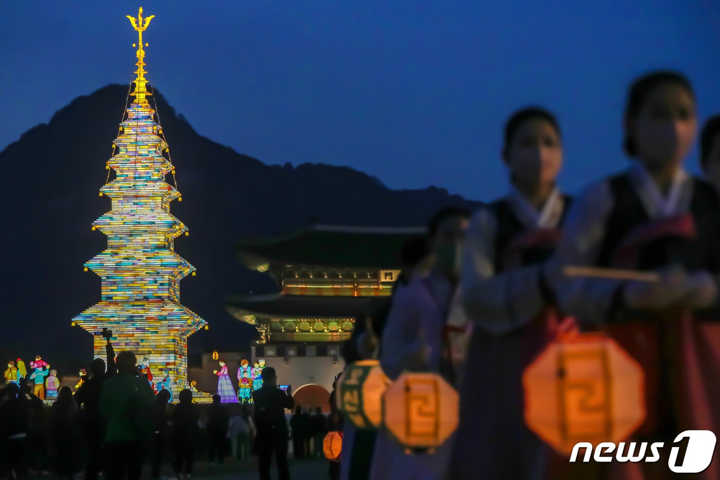 본문 이미지 - 26일 오후 서울 종로구 광화문광장에서 열린 '2023 부처님오신날 봉축점등식'에서 참석자들이 철물 구조와 한지 공예로 만든 20m 높이의 수마노탑 주변 탑돌이를 하고 있다. 2023.4.26/뉴스1 ⓒ News1 민경석 기자