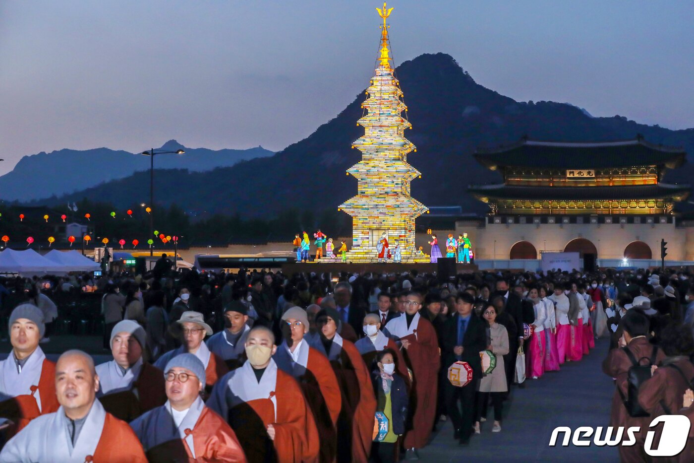 본문 이미지 - 26일 오후 서울 종로구 광화문광장에서 열린 '2023 부처님오신날 봉축점등식'에서 참석자들이 철물 구조와 한지 공예로 만든 20m 높이의 수마노탑 주변 탑돌이를 하고 있다. 2023.4.26/뉴스1 ⓒ News1 민경석 기자