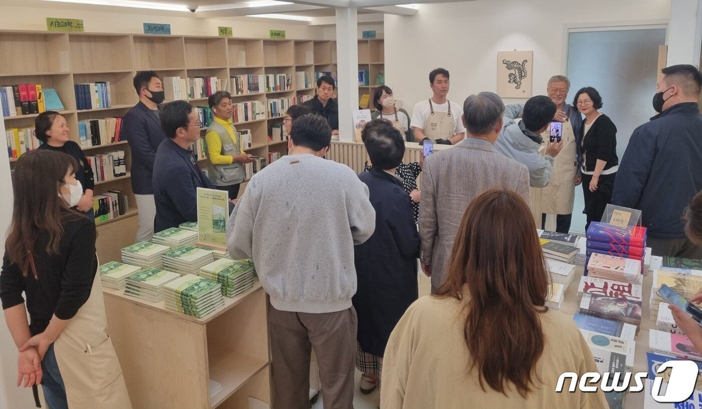본문 이미지 - 29일 양산 평산책방에 손님들이 가득 찬 가운데 문재인 전 대통령이 한 시민과 기념사진 촬영을 하고 있다./뉴스1 이현동 기자