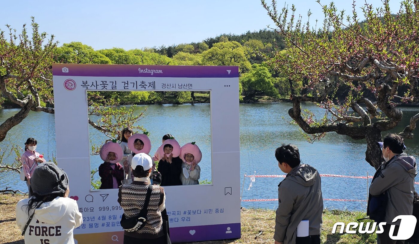본문 이미지 - 8일 경북 경산시 남산면 반곡지 일원에서 열린 복사길 꽃 걷기에 참여한 시민들이 반곡지를 배경으로 사진을 찍고 있다. 반곡지는 수백년된 왕버들 20여 그루가 줄지어 선 나무터널이 문화체육관광부 '사진찍기 좋은 녹색명소'로 선정된 곳이다. 2023.4.8/뉴스1 ⓒ News1 정우용 기자