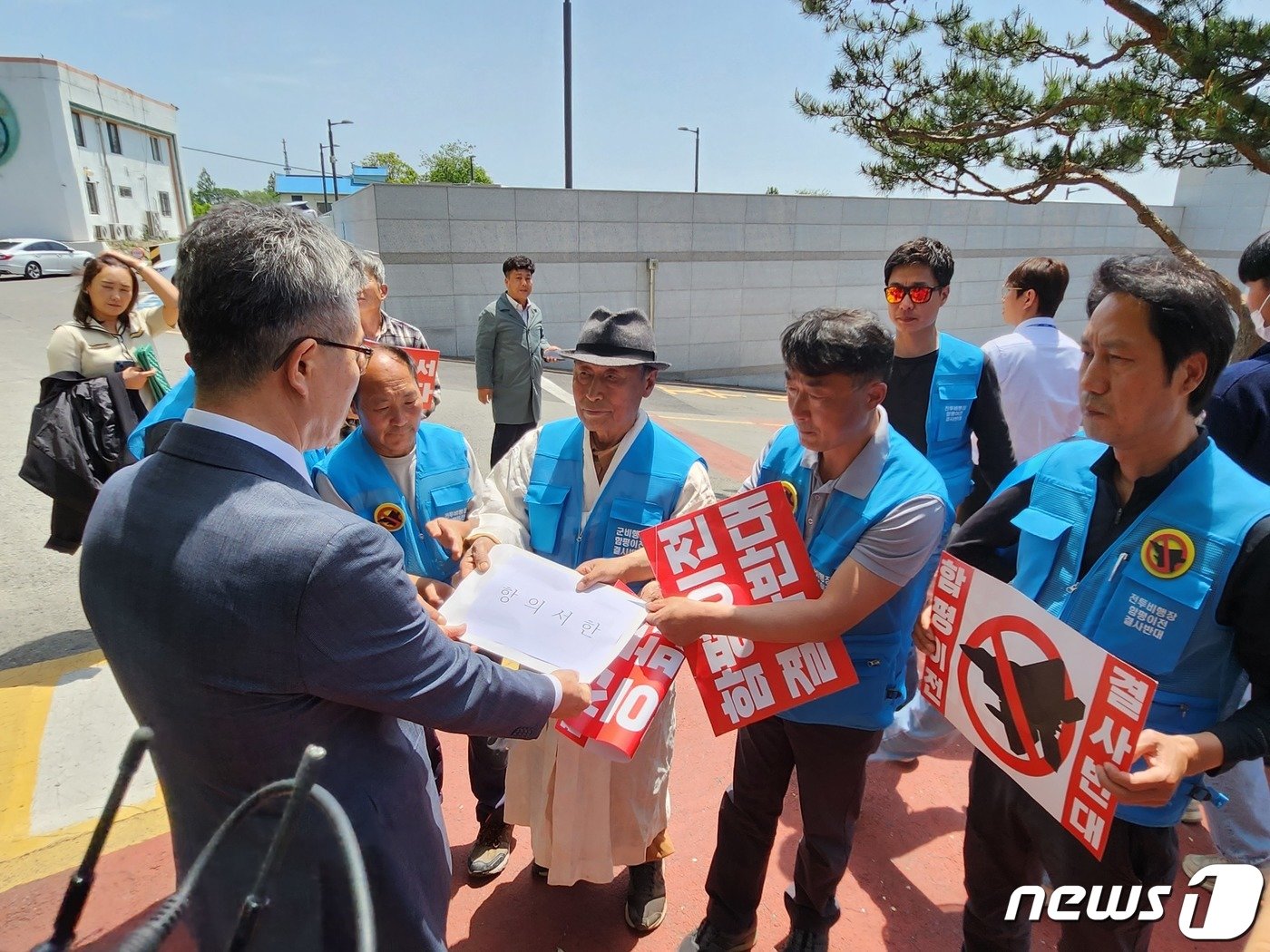 광주전투비행장 함평이전 저지를 촉구하는 함평군민들이 10일 함평군청을 항의방문해 이병용 함평 부군수에 항의서한을 전달하고 있다.2023.5.10./뉴스1