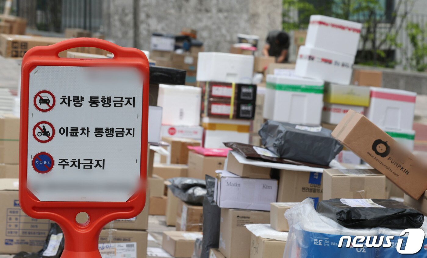 본문 이미지 - 10일 오후 경기 수원시의 한 대단지 아파트 정문에 택배들이 쌓여있다. 해당 아파트는 지난 1일부터 택배 차량의 지상 통행을 전면 금지하면서 택배 기사들이 문 앞까지 전달하던 택배 물건을 아파트 정문에 쌓아놓고 있다. 2023.5.10/뉴스1 ⓒ News1 김영운 기자