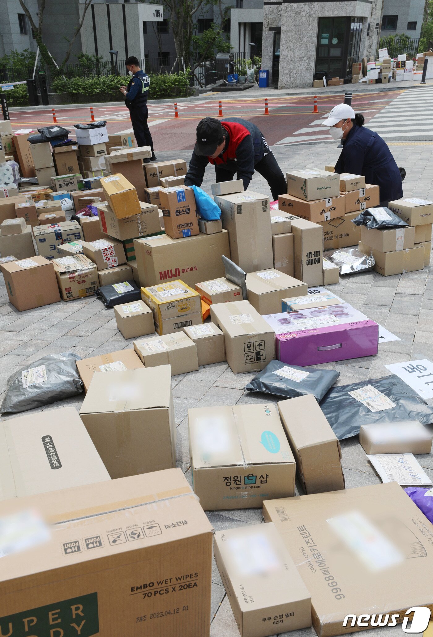 본문 이미지 - 10일 오후 경기 수원시의 한 대단지 아파트 정문에 택배들이 쌓여있다. 해당 아파트는 지난 1일부터 택배 차량의 지상 통행을 전면 금지하면서 택배 기사들이 문 앞까지 전달하던 택배 물건을 아파트 정문에 쌓아놓고 있다. 2023.5.10/뉴스1 ⓒ News1 김영운 기자
