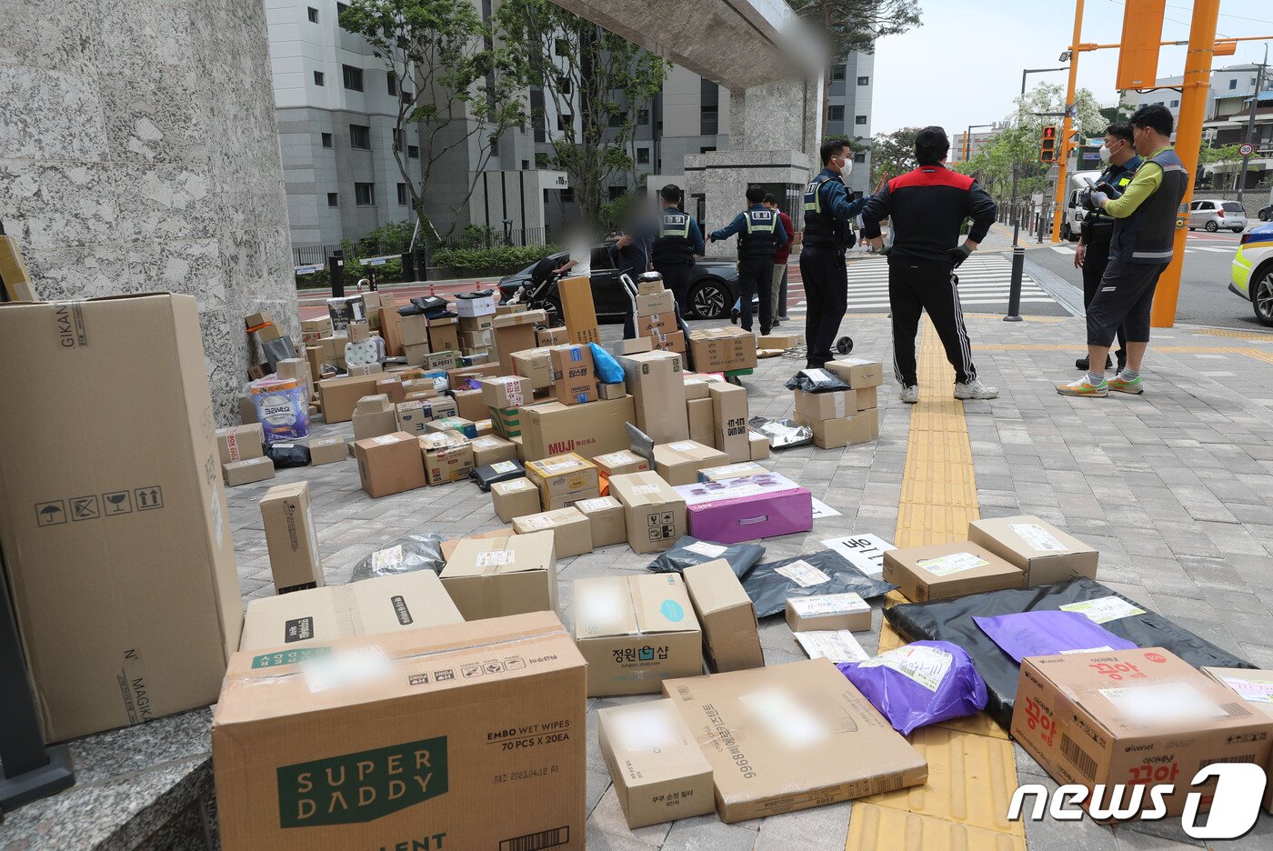 본문 이미지 - 10일 오후 경기 수원시의 한 대단지 아파트 정문에 택배들이 쌓여있다. 해당 아파트는 지난 1일부터 택배 차량의 지상 통행을 전면 금지하면서 택배 기사들이 문 앞까지 전달하던 택배 물건을 아파트 정문에 쌓아놓고 있다. 2023.5.10/뉴스1 ⓒ News1 김영운 기자