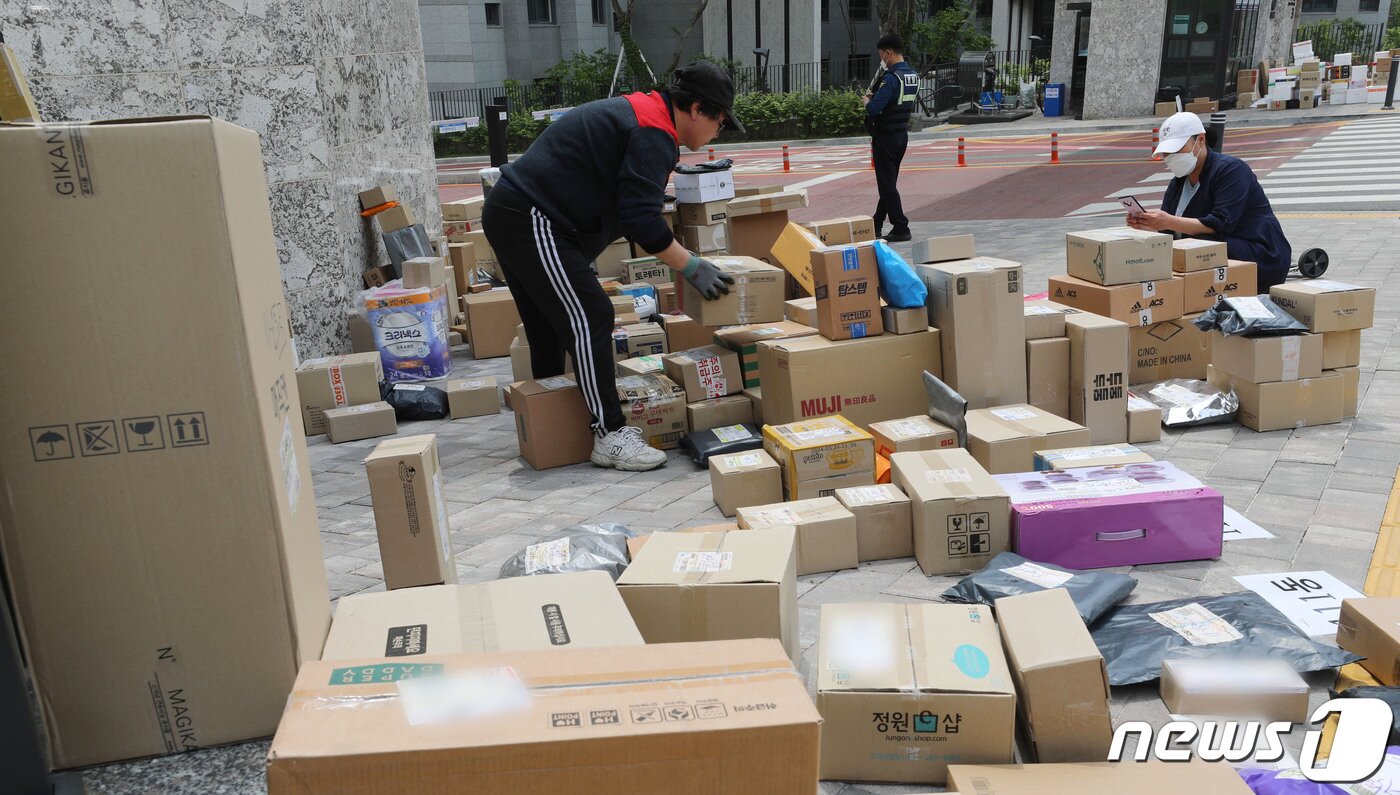 본문 이미지 - 10일 오후 경기 수원시의 한 대단지 아파트 정문에 택배들이 쌓여있다. 해당 아파트는 지난 1일부터 택배 차량의 지상 통행을 전면 금지하면서 택배 기사들이 문 앞까지 전달하던 택배 물건을 아파트 정문에 쌓아놓고 있다. 2023.5.10/뉴스1 ⓒ News1 김영운 기자