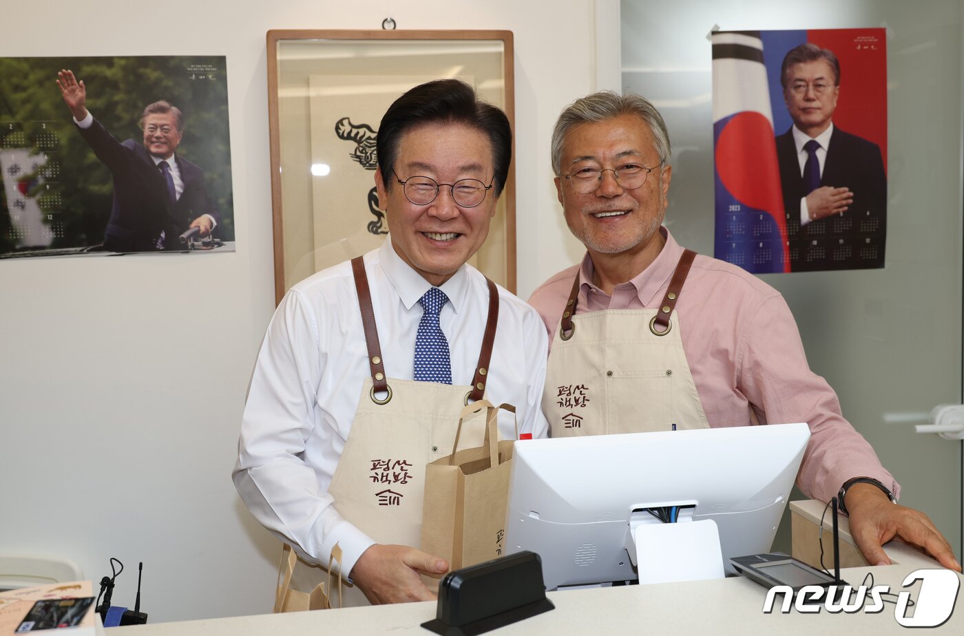 본문 이미지 - 이재명 더불어민주당 대표가 지난해 5월10일 오후 문재인 전 대통령이 최근 경남 양산 평산마을에 문을 연 평산책방을 찾아 계산대에서 봉사를 마친 뒤 기념사진을 찍고 있다. (공동취재)/뉴스1 ⓒ News1 윤일지