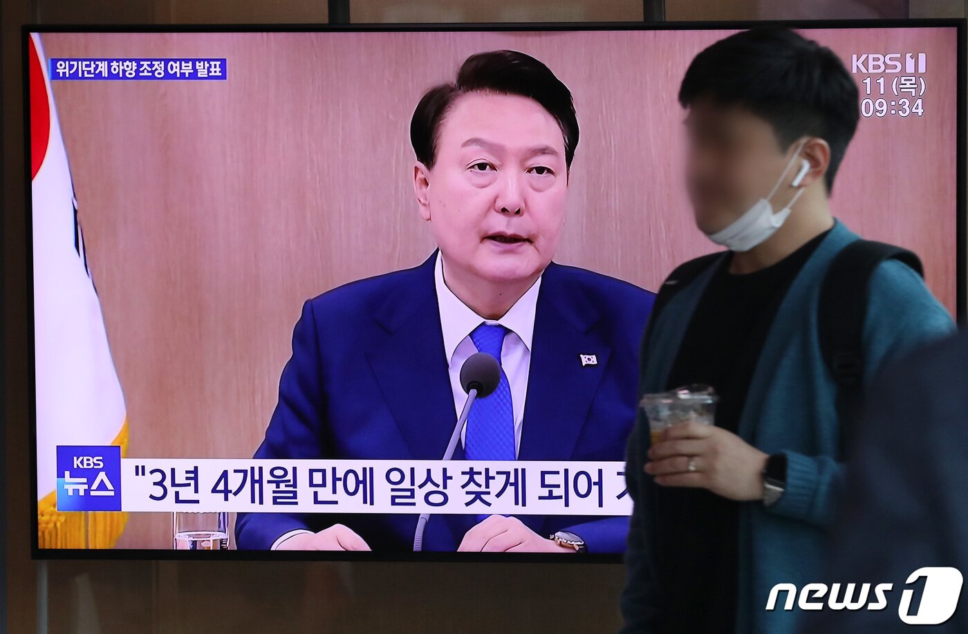본문 이미지 - 11일 오전 서울역 대합실에서 시민들이 윤석열 대통령이 주재하는 코로나19 중앙재난안전대책본부 회의를 생방송으로 시청하고 있다. 윤 대통령은 이날 대국민 담화를 통해 코로나19 위기경보를 ‘심각’에서 ‘경계’ 단계로 조정하고 방역 조치 대부분을 해제한다고 밝혔다. 2023.5.11/뉴스1 ⓒ News1 이동해 기자