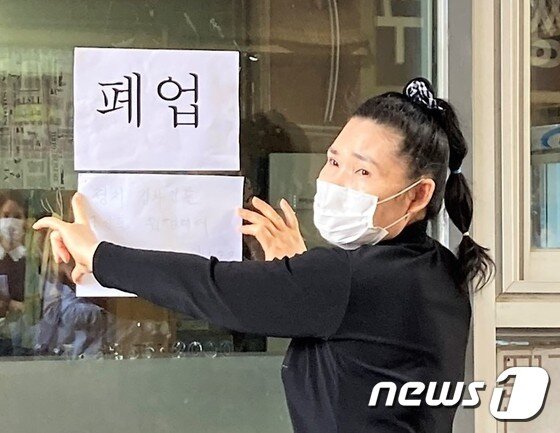 본문 이미지 - 손원주 흑돈연가 사장이 지난 2020년9월18일 오후 본인의 가게 앞에 폐업을 알리는 글귀를 붙이고 있다. (소상공인연합회 제공) /2020.09.18 ⓒ 뉴스1