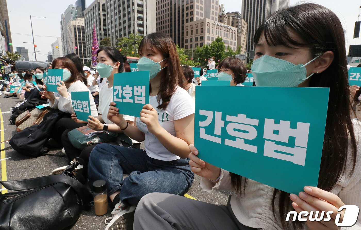 본문 이미지 - 대한간호협회 간호사들이 지난 12일 오후 서울 동화면세점 앞 세종대로에서 열린 국제간호사의 날 기념 집회에서 피켓을 들고 간호법 제정을 촉구하고 있다./뉴스1 ⓒ News1 박세연 기자