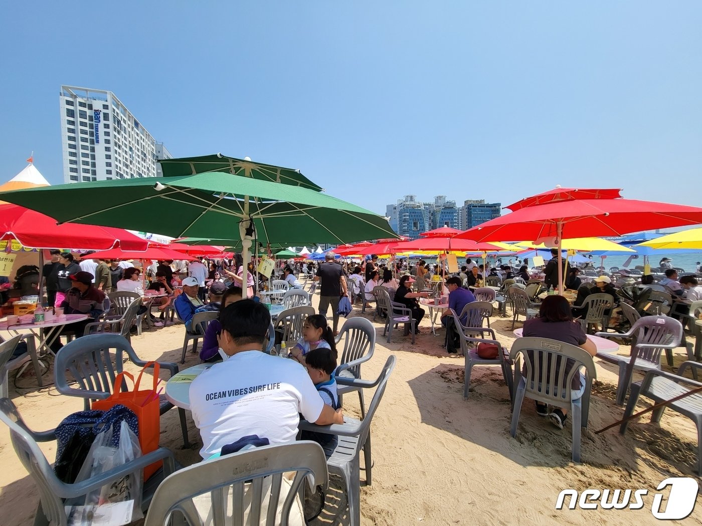 ‘제21회 광안리어방축제’를 찾은 시민들이 먹거리 부스 앞에 설치된 파라솔에서 다회용기에 담긴 음식을 즐기고 있다.&#40;독자 제공&#41;