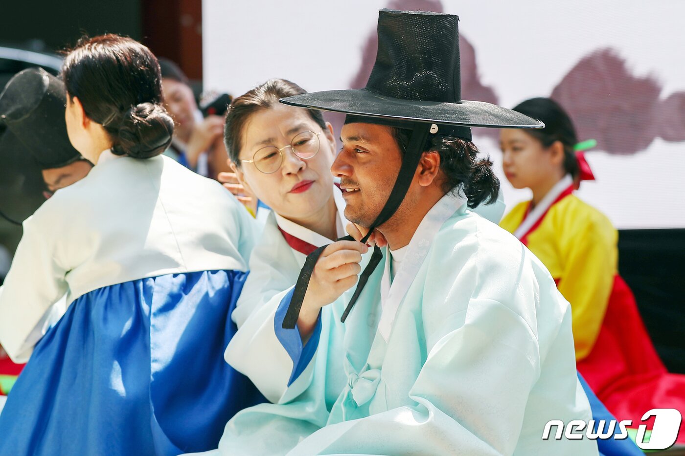 본문 이미지 - 성년의날을 하루 앞둔 14일 오후 서울 중구 덕수궁 돌담길에서 열린 '전통 성년례'에서 올해 성년을 맞은 대학생들이 의복과 갓을 착용하는 가례(加禮)를 치르고 있다. 2023.5.14/뉴스1 ⓒ News1 민경석 기자