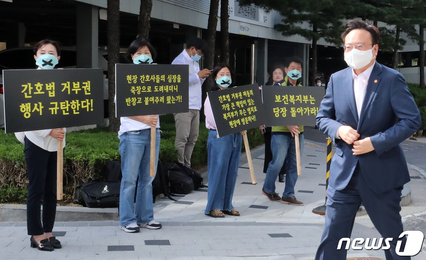 본문 이미지 - 조규홍 보건복지부 장관이 16일 오후 서울 성북구 고려대학교 안암병원에서 열리는 진료지원인력 현장 간담회에 참석하며 윤석열 대통령의 간호법 거부권 행사 규탄 피켓을 든 간호사들 앞을 지나고 있다. 2023.5.16/뉴스1 ⓒ News1 김진환 기자