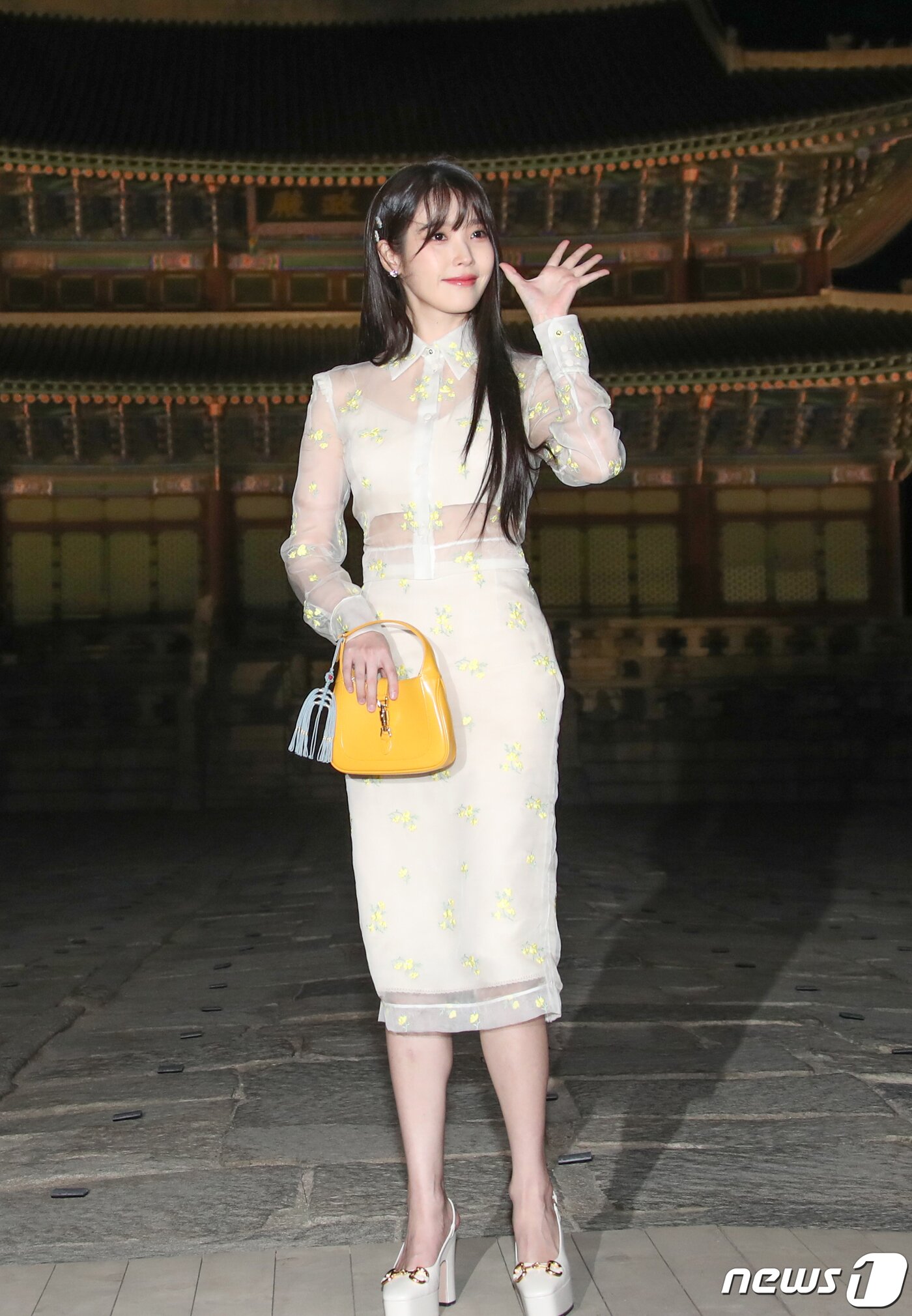 본문 이미지 - 가수 겸 배우 아이유가 16일 서울 종로구 경복궁 근정전 입구에서 진행된 구찌(Gucci)의 2024 크루즈 쇼 포토콜 행사에서 손 인사를 하고 있다. ⓒ News1 권현진 기자