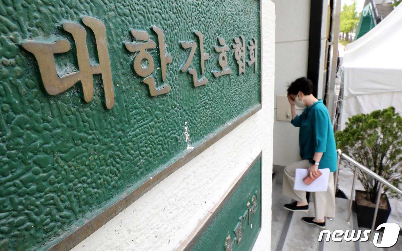 본문 이미지 - 대한간호협회가 대리처방과 수술 등 불법 의료행위를 거부하고 간호사 면허증 반납 운동을 벌이겠다고 밝힌 17일 서울 중구 대한간호협회 회관 앞으로 관계자가 이동하고 있다. 간호협회는 이날 기자회견을 열고 "16일 윤석열 대통령이 공약인 간호법을 거부하는 초유의 사태가 발생했다＂면서 ＂1차 단체행동 방향으로 의사의 불법 의료행위 지시를 거부하는 준법투쟁을 전개하고 간호사 면허증 반납운동을 전개할 것＂이라고 밝혔다. 2023.5.17/뉴스1 ⓒ News1 박지혜 기자