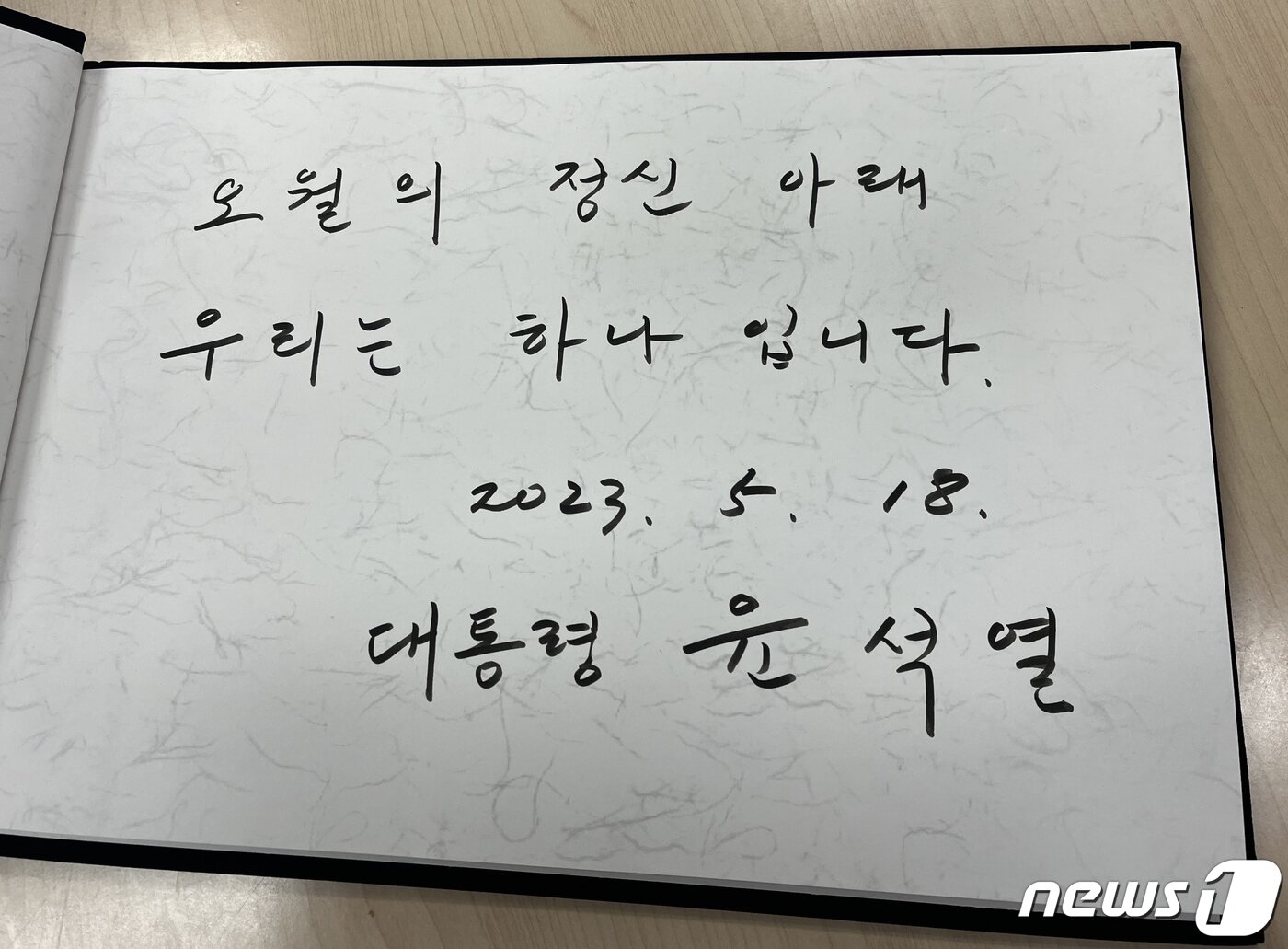 본문 이미지 - 윤석열 대통령이 18일 광주 북구 운정동 국립5·18민주묘지에서 열린 제43주년 5·18민주화운동 기념식에 참석해 '오월의 정신 아래 우리는 하나 입니다'라고 방명록을 작성했다.2023.5.18/뉴스1 ⓒ News1 이승현 기자