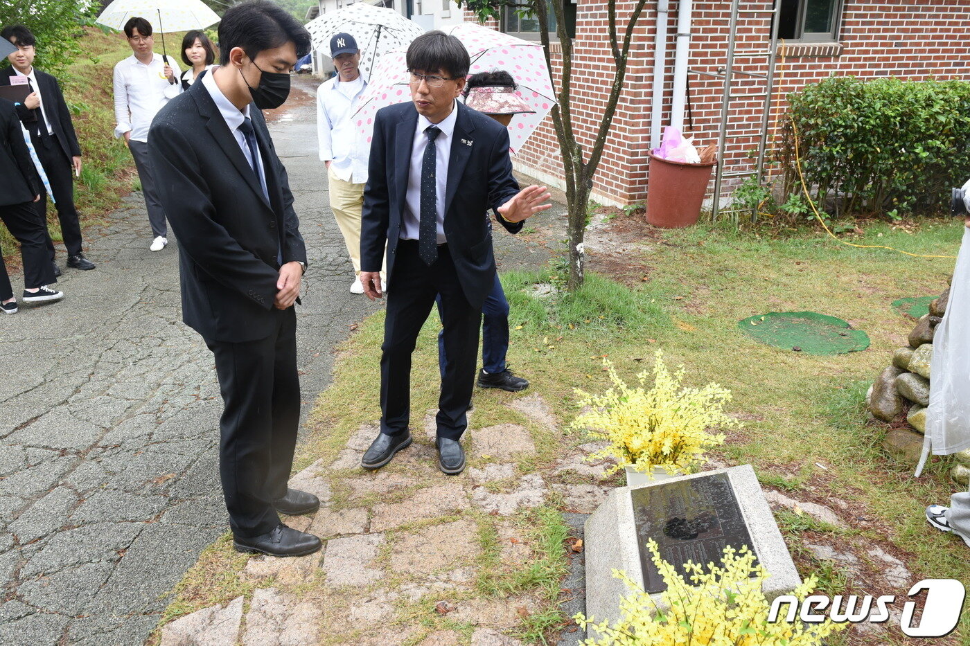 본문 이미지 - 고(故) 전두환씨의 손자 전우원씨(27)가 제43주년 5·18민주화운동 당일인 18일 오전 국립민주묘지 망월동 민족민주열사묘역(구묘역)을 찾아 위르겐 힌츠페터 비석에 대한 설명을 듣고 있다.2023.5.18/뉴스1 ⓒ News1 김동수 기자