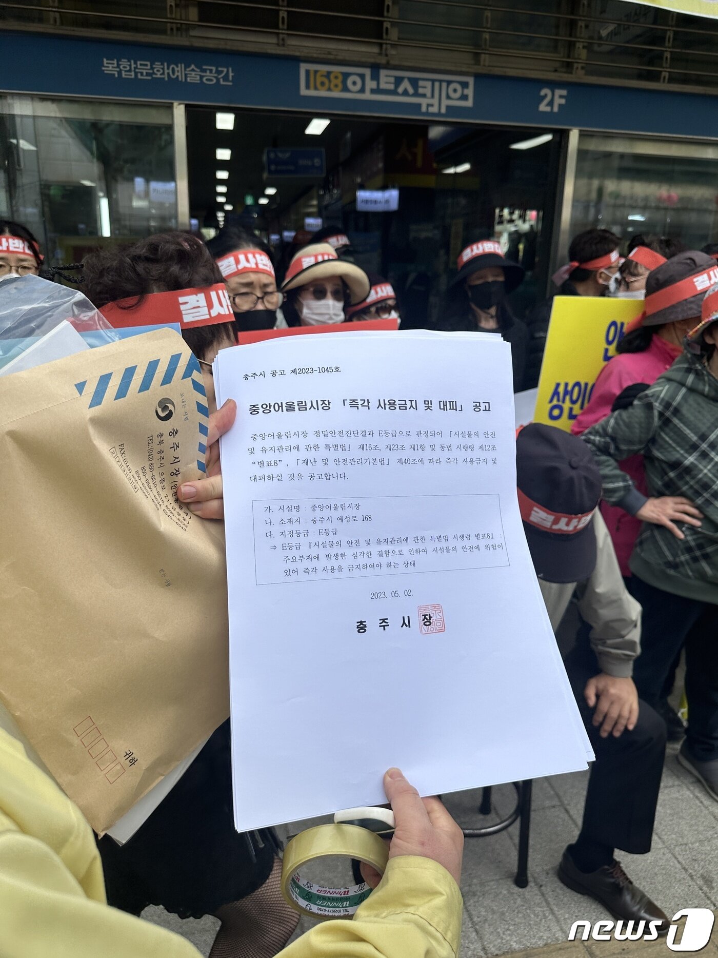 본문 이미지 - 2일 충북 충주중앙어울림시장 안전진단 'E등급'에 따른 시설 사용금지 조치에 앞서 충주시 공무원이 상인들에게 공고문을 보여주고 있다.2023.5.2/뉴스1 ⓒ News1 윤원진 기자