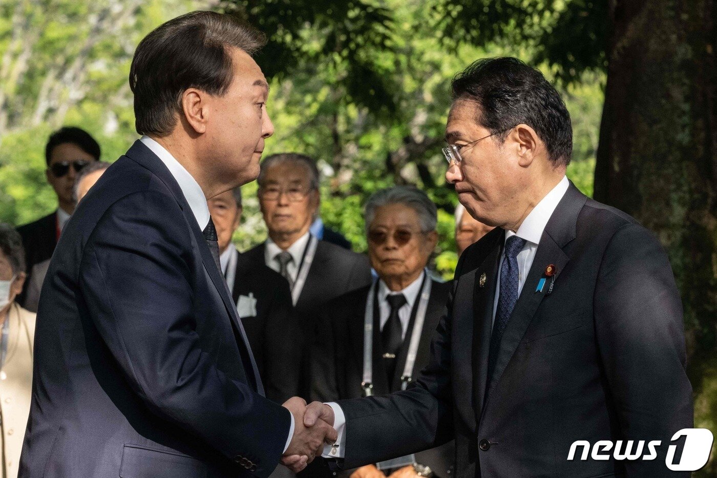 본문 이미지 - 주요 7개국&#40;G7&#41; 정상회의 참관국 자격으로 일본을 방문 중인 윤석열 대통령이 21일 오전 일본 히로시마 평화기념공원에 있는 한국인 원폭 희생자 위령비 참배에 앞서 기시다 후미오&#40;岸田文雄&#41; 일본 총리와 악수하고 있다. ⓒ AFP=뉴스1 ⓒ News1 최종일 기자