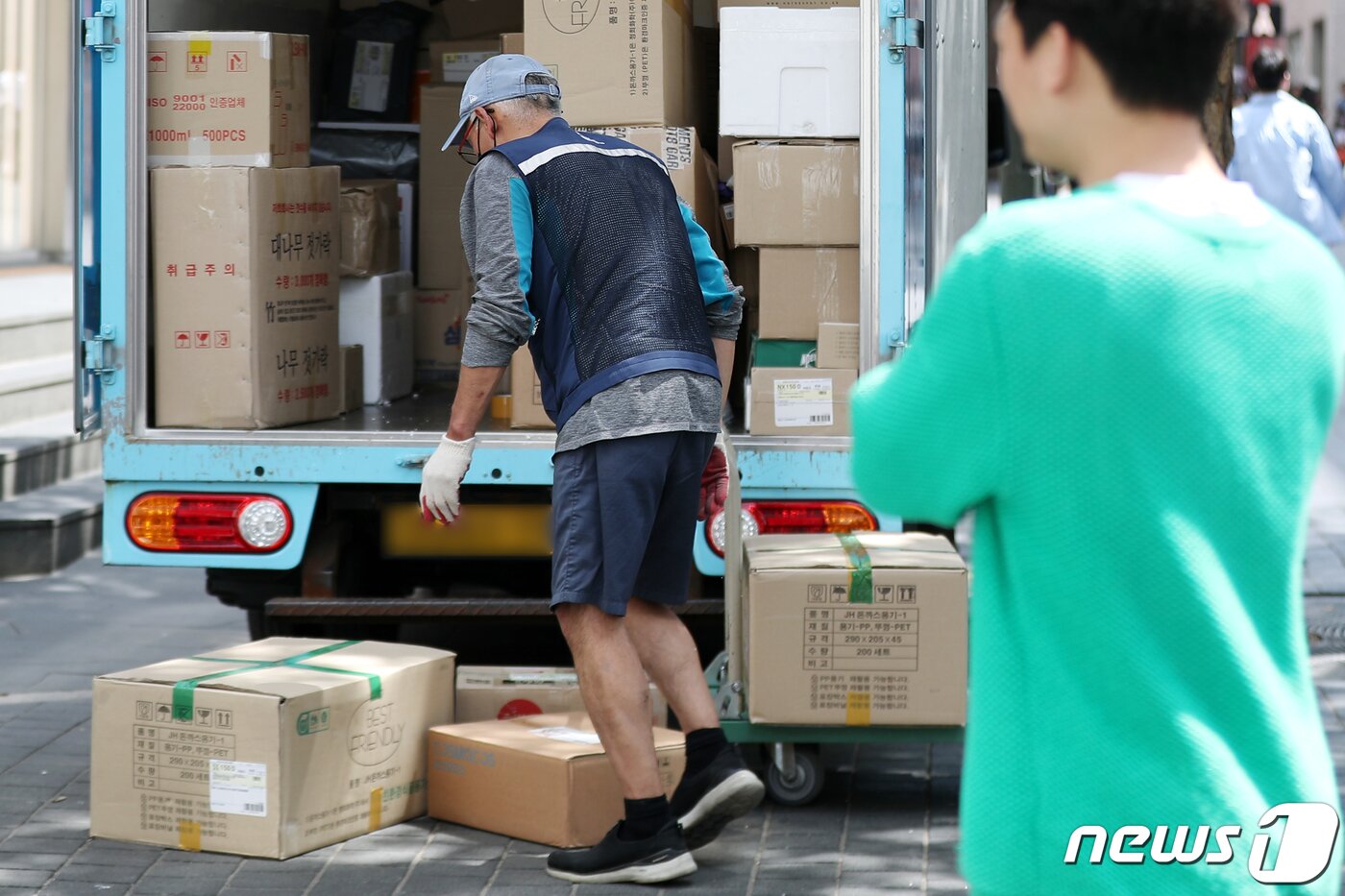 본문 이미지 - 서울 중구 명동 거리에서 한 택배 근로자가 배송 업무를 하고 있다. /뉴스1 ⓒ News1 민경석 기자