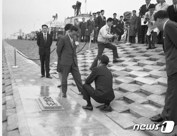 본문 이미지 - 1968년 6월 1일 서울 여의도 제방완공 기념식에서 박정희 전 대통령이 '한강개발'이라는 친필 휘호석을 살피는 모습. (사진=서울 역사박물관) ⓒ 뉴스1