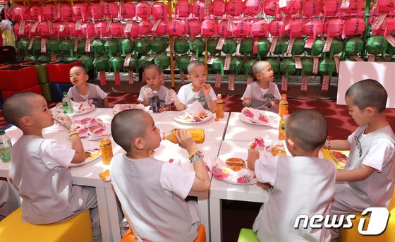 동자승들이 24일 서울 종로구 조계사에서 신세계푸드가 마련한 100% 식물성 비건 '베러 버거'를 먹고 있다. 2023.5.24/뉴스1 © News1 안은나 기자