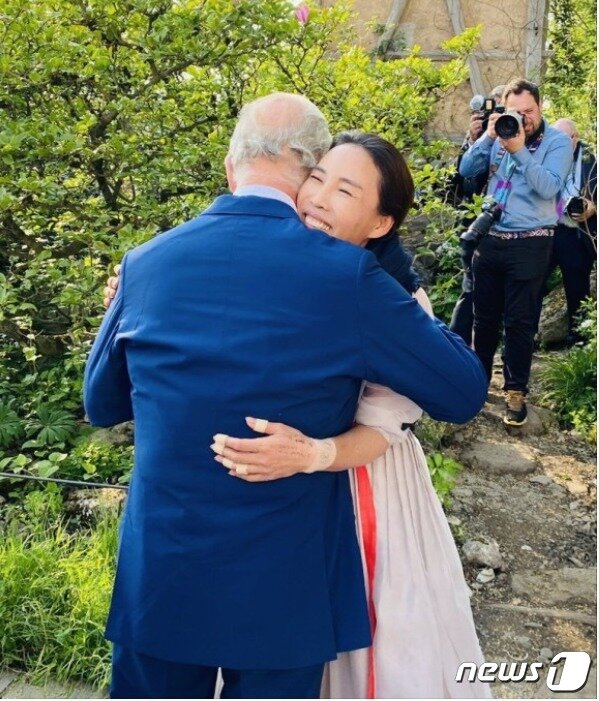 본문 이미지 - 지난 22일(현지시간) '첼스 플라워쇼'를 깜짝 방문한 찰스 3세 영국 국왕이 '한번 안아봐도 되겠는가'라는 황지해 작가의 요청을 흔쾌히 응해주고 있다. (사진=황지해) ⓒ 뉴스1 