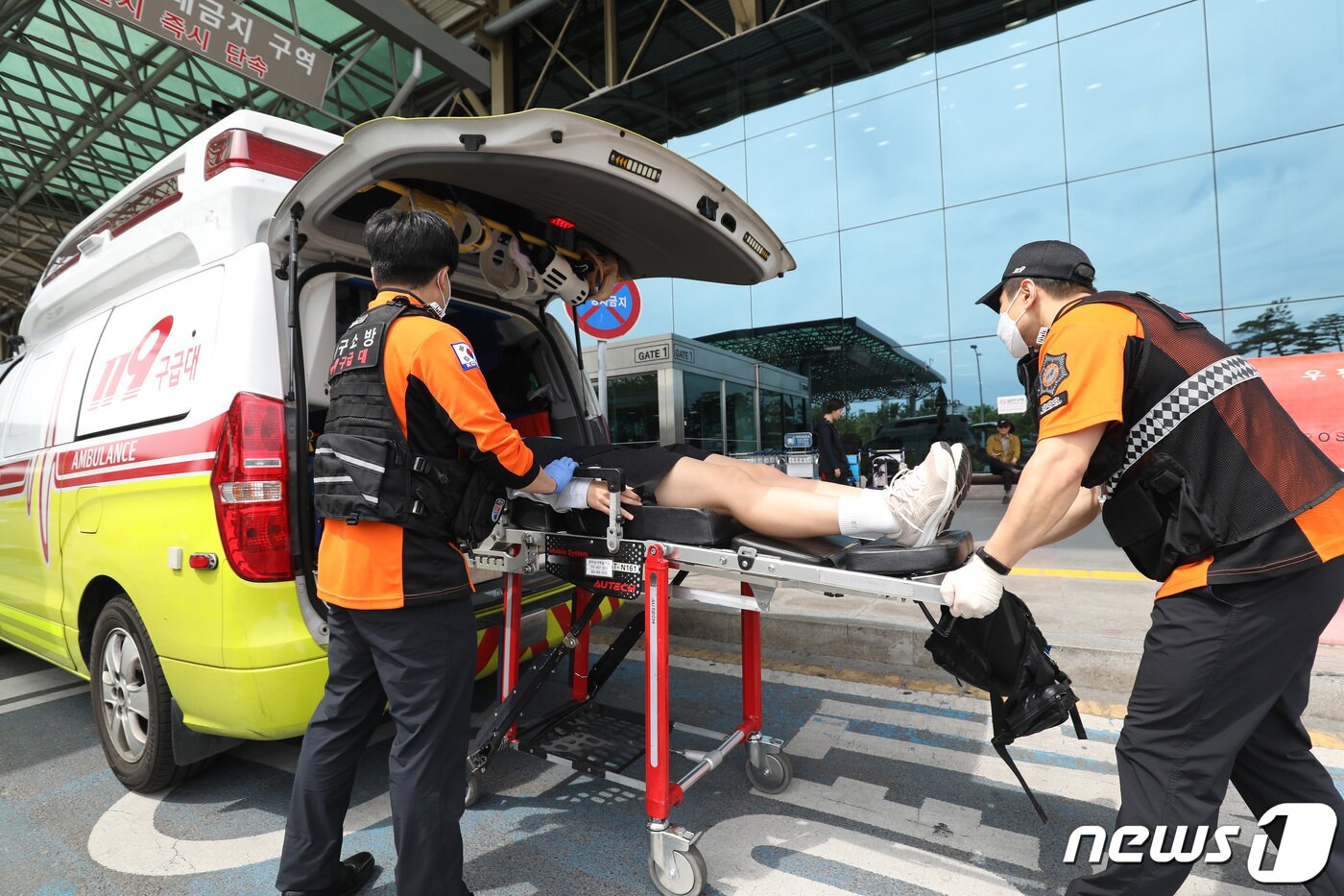 본문 이미지 - 26일 오전 제주공항을 출발해 대구공항으로 향하던 아시아나 항공기에서 비행 중 문이 열리는 사고가 발생했다. 울산에서 열리는 제52회 전국소년체육대회에 참가하기 위해 비행기에 탑승했던 초·중학생 제주특별자치도 선수단 가운데 대구공항 도착 직후 고통을 호소하는 선수들을 119구조대가 병원으로 이송하기 위해 들것을 이용해 구급차로 옮기고 있다. 2023.5.26/뉴스1 ⓒ News1 공정식 기자