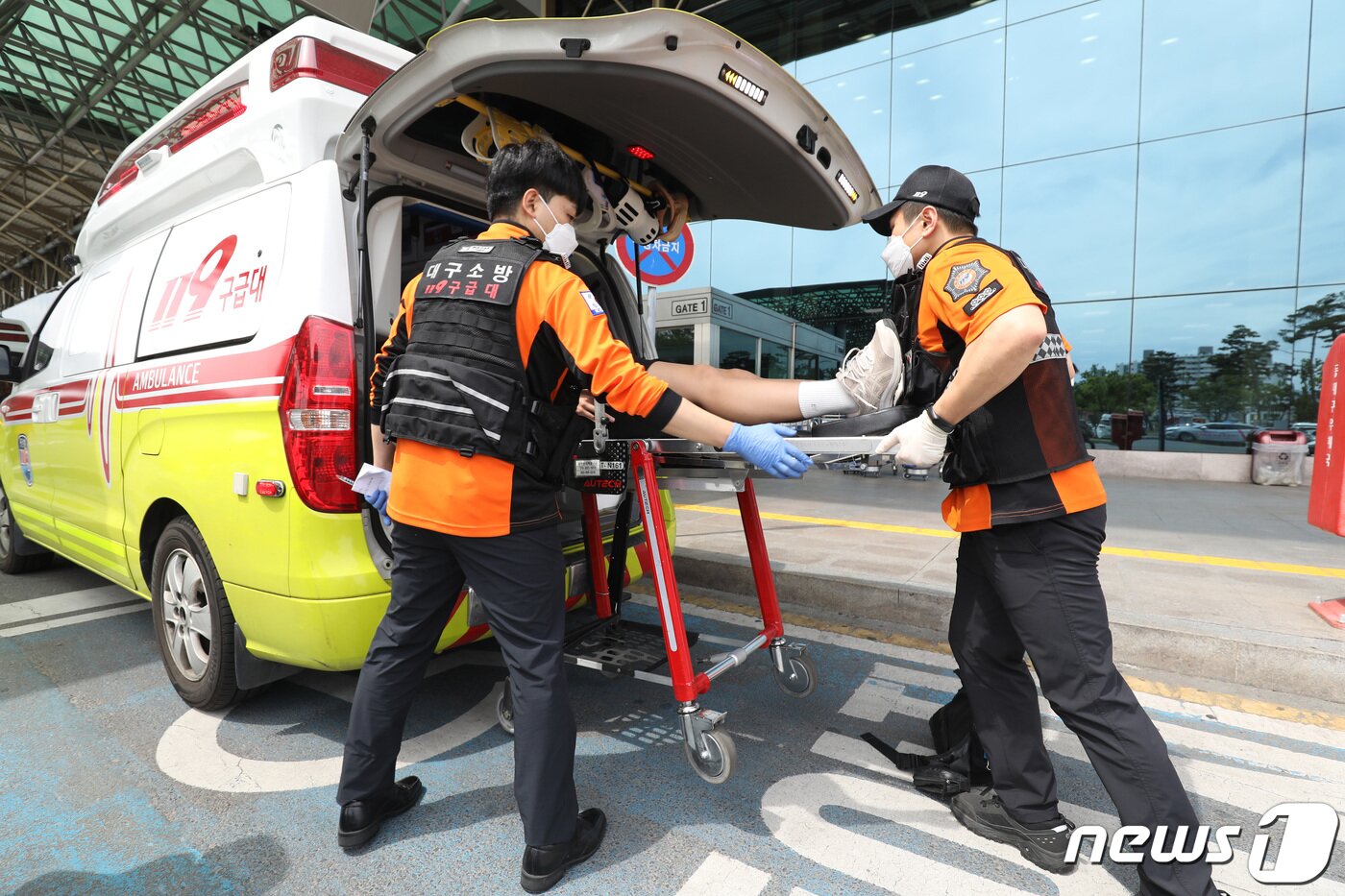 본문 이미지 - 26일 오전 제주공항을 출발해 대구공항으로 향하던 아시아나 항공기에서 비행 중 문이 열리는 사고가 발생했다. 울산에서 열리는 제52회 전국소년체육대회에 참가하기 위해 비행기에 탑승했던 초·중학생 제주특별자치도 선수단 가운데 대구공항 도착 직후 고통을 호소하는 선수들을 119구조대가 병원으로 이송하기 위해 들것을 이용해 구급차로 옮기고 있다. 2023.5.26/뉴스1 ⓒ News1 공정식 기자