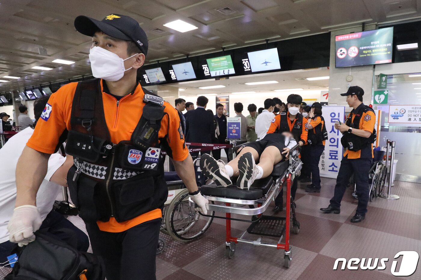 본문 이미지 - 26일 오전 제주공항을 출발해 대구공항으로 향하던 아시아나 항공기에서 비행 중 문이 열리는 사고가 발생했다. 울산에서 열리는 제52회 전국소년체육대회에 참가하기 위해 비행기에 탑승했던 초·중학생 제주특별자치도 선수단 가운데 대구공항 도착 직후 고통을 호소하는 선수들을 119구조대가 들것을 이용해 구급차로 옮기고 있다. 2023.5.26/뉴스1 ⓒ News1 공정식 기자