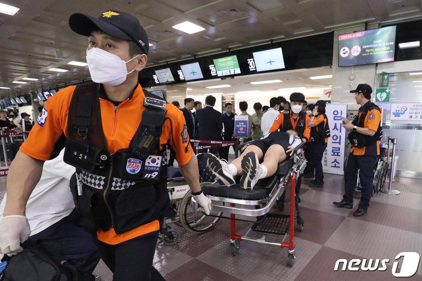 본문 이미지 - 26일 오전 제주공항을 출발해 대구공항으로 향하던 아시아나 항공기에서 비행 중 문이 열리는 사고가 발생했다. 울산에서 열리는 제52회 전국소년체육대회에 참가하기 위해 비행기에 탑승했던 초·중학생 제주특별자치도 선수단 가운데 대구공항 도착 직후 고통을 호소하는 선수들을 119구조대가 들것을 이용해 구급차로 옮기고 있다. 2023.5.26/뉴스1 ⓒ News1 공정식 기자