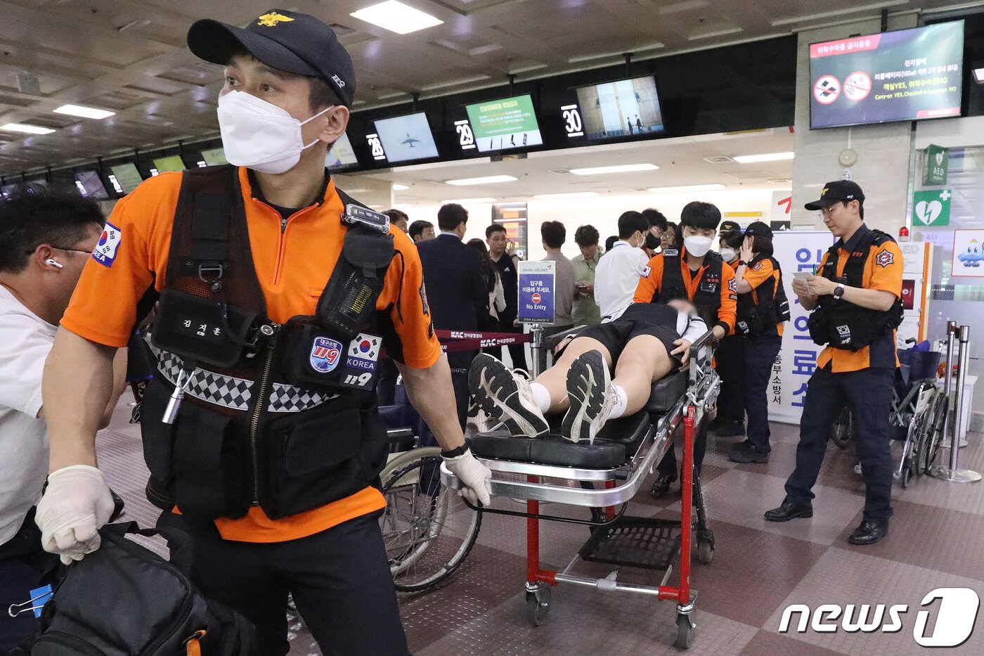 본문 이미지 - 119구조대가 전국소년체육대회에 참가하기 위해 항공기에 탑승했던 초·중학생 제주특별자치도 선수단 가운데 대구공항 도착 직후 고통을 호소하는 선수들을 들것을 이용해 구급차로 옮기고 있다. 2023.5.26/뉴스1 ⓒ News1 공정식 기자