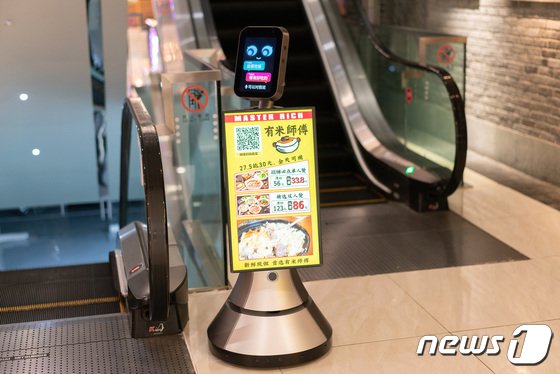 중국 선전 화창베이 한 쇼핑몰에서 서비스 로봇이 음식점 광고를 내보내고 있다. 2023.5.17/뉴스1 ⓒ News1 이기범 기자