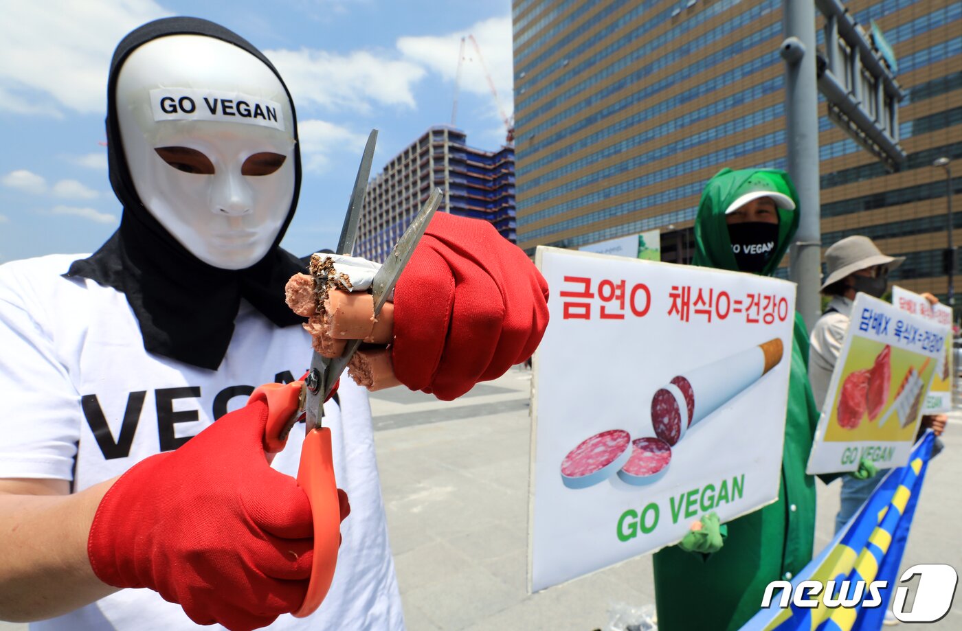 본문 이미지 -  서울 광화문 광장에서 가진 세계 금연의 날을 맞아 금연과 채식으로 건강 촉구 기자회견에서 소시지와 담배를 가위로 자르는 퍼포먼스를 펼치고 있다. 이들은 1군 발암물질인 담배와 함께 세계보건기구 산하 국제암연구소가 햄, 소시지, 베이컨 등 가공육은 1군, 적색육은 2군 발암물질로 분류했다며, 심장병, 암, 당뇨병, 고혈압 등으로 인한 사망자의 80%가량이 육식으로 인한 사망인 것으로 추정해 금연과 채식으로 건강한 사회를 만들 것을 촉구했다. 2023.5.31/뉴스1 ⓒ News1 박정호 기자
