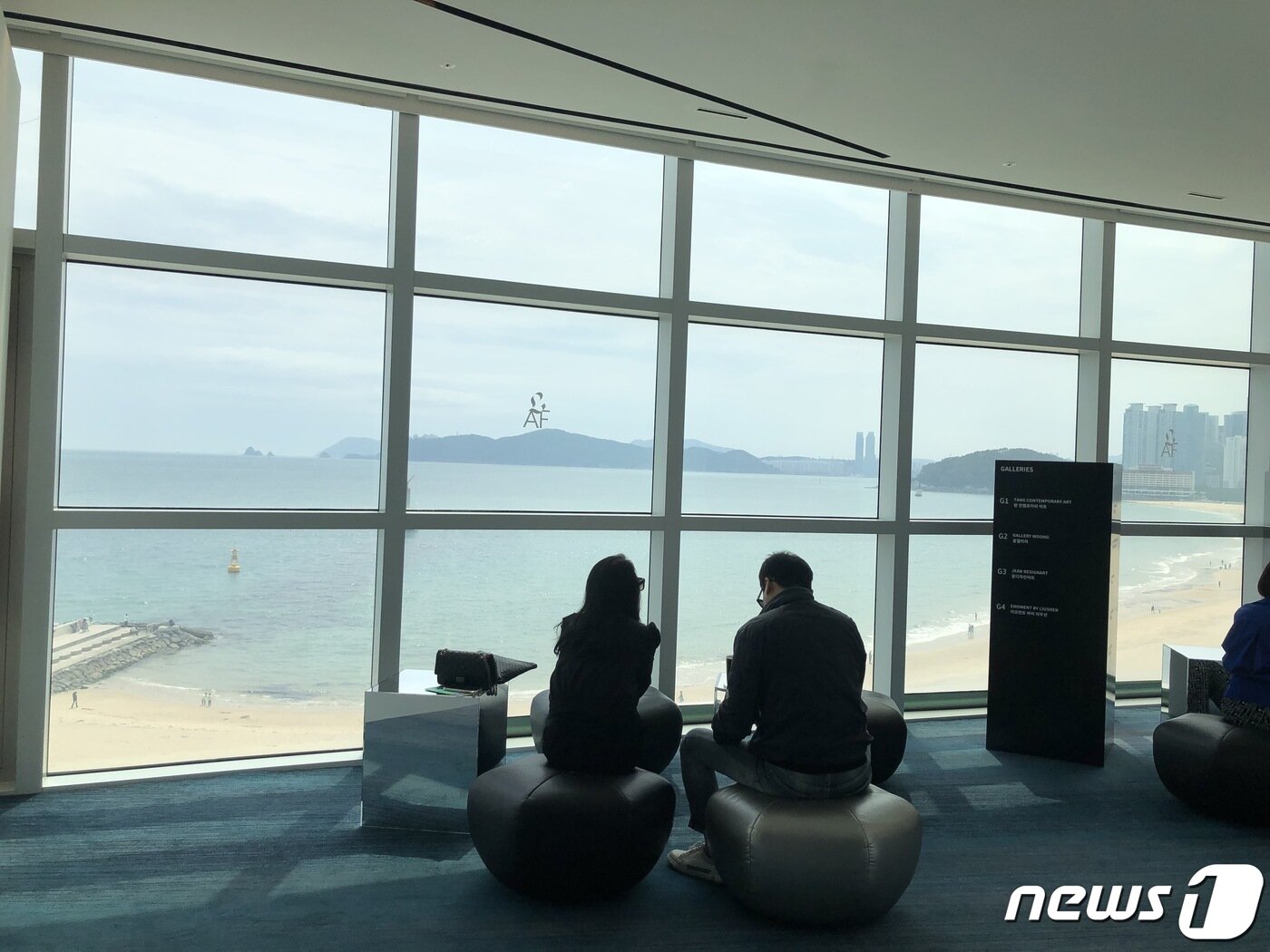 본문 이미지 - '2023 롯데아트페어 부산'에 방문한 관람객들이 족두리 방석에 앉아 바다 전경을 감상하고 있다.2023.5.03/뉴스1 ⓒ News1 박상아 인턴기자