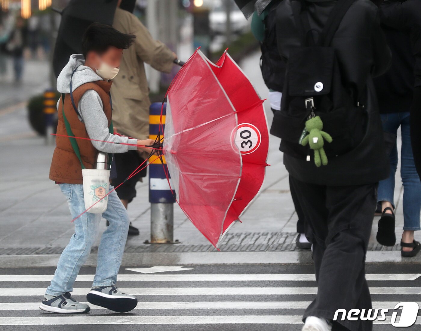 본문 이미지 - 부산에 호우·강풍특보가 내려진 5일 부산 해운대해수욕장 인근에서 한 어린이가 몰아치는 비바람에 우산을 부여잡고 힘겹게 걷고 있다. 2023.5.5/뉴스1 ⓒ News1 윤일지 기자