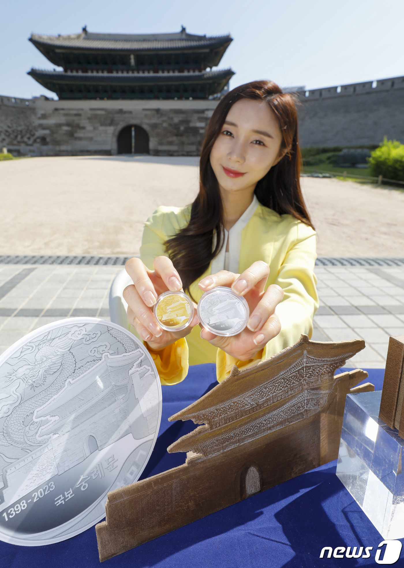 (서울=뉴스1) 김도우 기자 = 8일 서울 중구 숭례문에서 열린 '국보 숭례문' 기념메달 디자인 공개 행사에서 모델이 기념메달을 소개하고 있다.풍산화동양행은 숭례문 건축 625년을 …