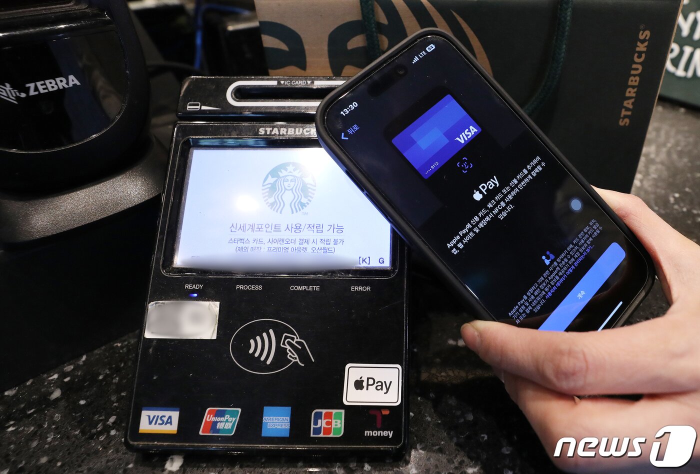 본문 이미지 - 서울 시내 한 스타벅스 매장에서 애플페이 가능 스티커가 부착된 NFC 단말기. 2023.5.8/뉴스1 ⓒ News1 김진환 기자