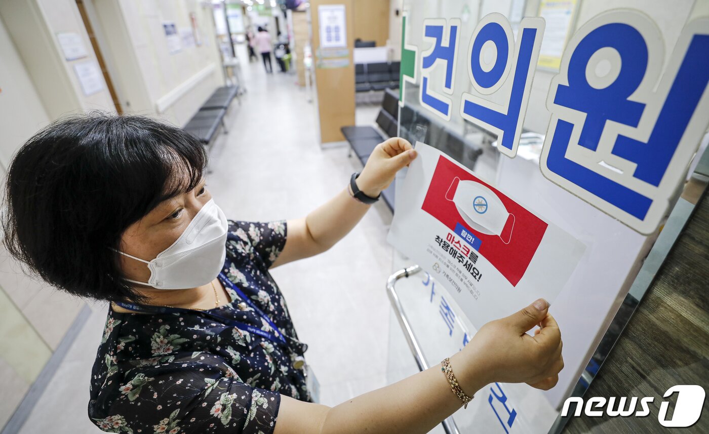 본문 이미지 - 코로나19 위기 경보 수준이 '심각'에서 '경계'로 하향 된 1일 서울 광진구 인구보건복지협회 가족보건의원에서 직원이 마스크 착용 안내문을 떼고 있다. 정부는 이날부터 신종 코로나바이러스 감염증(코로나19) 감염병 위기 경보 단계를 '심각'에서 '경계로' 내리고, 의원·약국 마스크 의무 해제, 확진자에 대한 격리 의무 폐지, 임시 선별검사소 운영종료 등 방역조치를 완화한다. 2023.6.1/뉴스1 ⓒ News1 김도우 기자