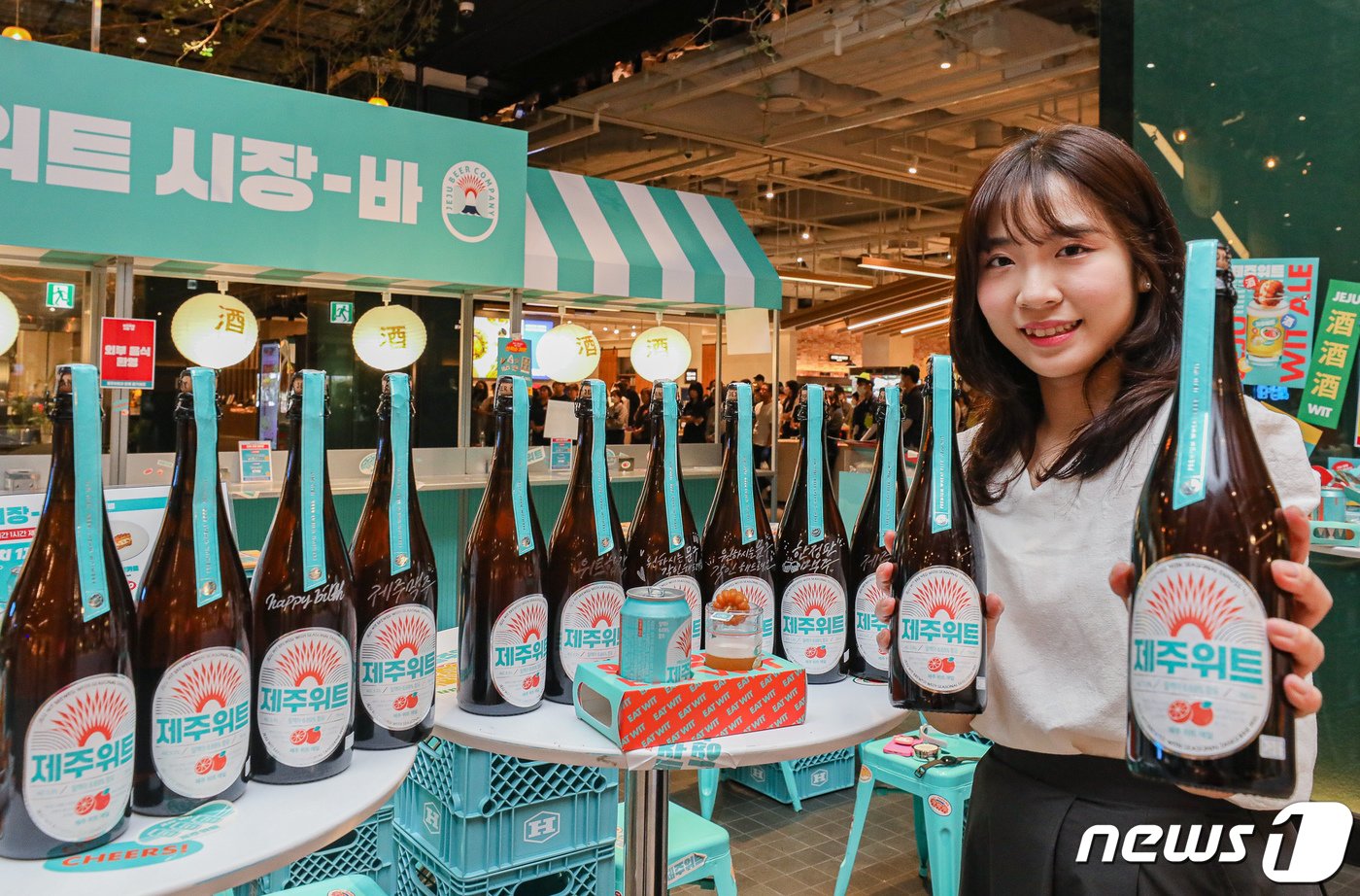 본문 이미지 - 12일 오전 서울 영등포구 더현대 서울 지하 1층 제주맥주 팝업스토어 '제주위트 시장-바'에서 직원이 신제품 '빅보틀'을 소개하고 있다. 현대백화점은 오는 14일까지 더현대 서울 지하 1층 행사장에서 제주맥주 팝업스토어 '제주위트 시장-바'를 연다. (현대백화점 제공) 2023.6.12/뉴스1