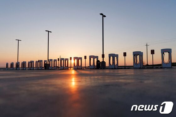 캘리포니아주 케틀맨시에 설치된 테슬라 충전소 뒤로 태양이 지고 있다. © 로이터=뉴스1 © News1 박형기 기자