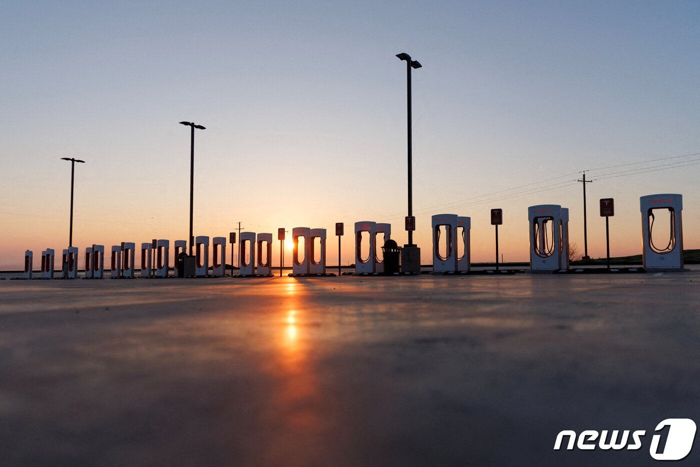 본문 이미지 - 캘리포니아주 케틀맨시에 설치된 테슬라 충전소 뒤로 태양이 지고 있다. ⓒ 로이터=뉴스1 ⓒ News1 박형기 기자