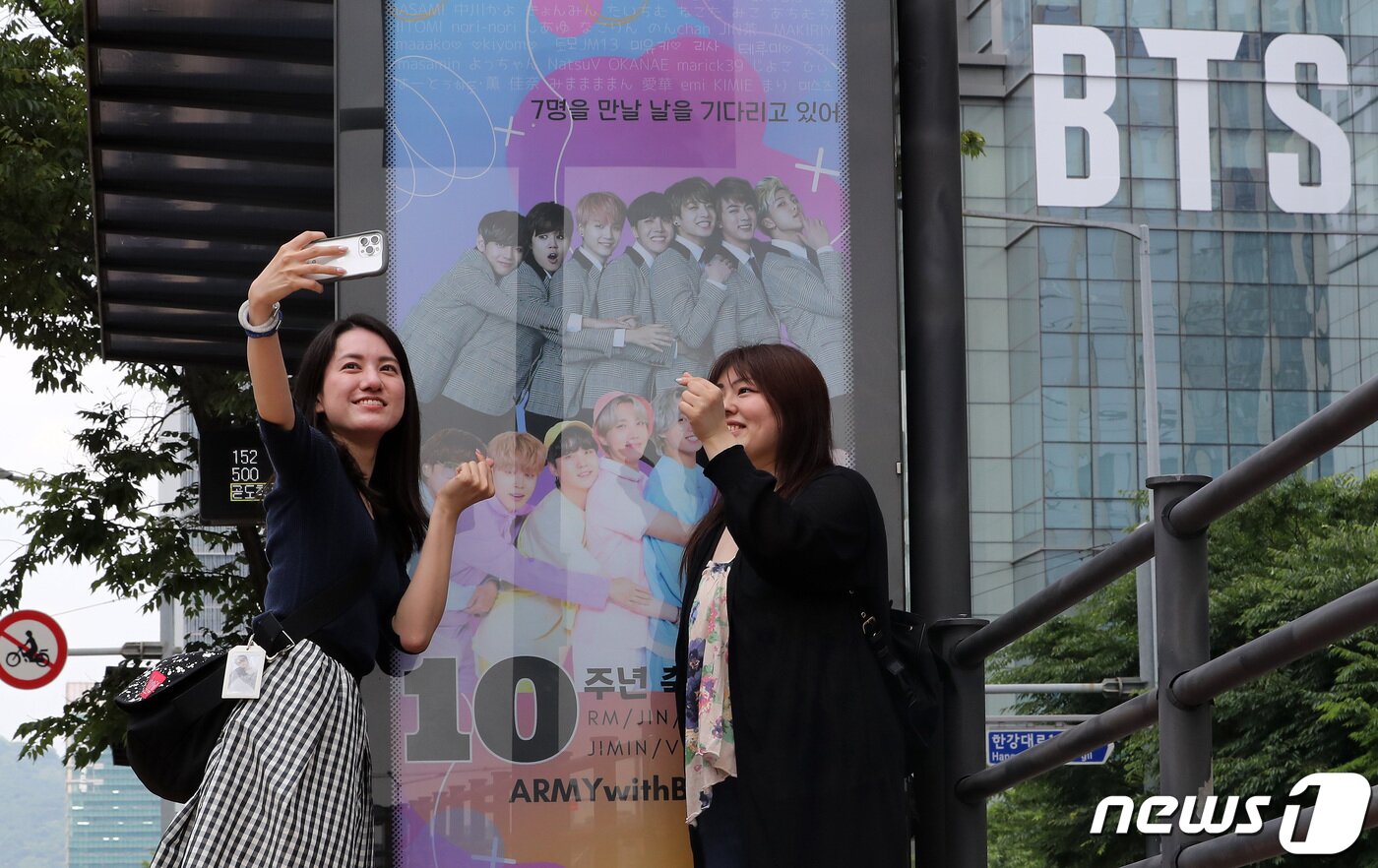 본문 이미지 - 12일 서울 용산구 하이브 사옥에서 해외팬들이 그룹 방탄소년단(BTS) 데뷔 10주년을 축하하는 광고판을 배경으로 기념사진을 찍고 있다. 2023.6.12/뉴스1 ⓒ News1 이동해 기자